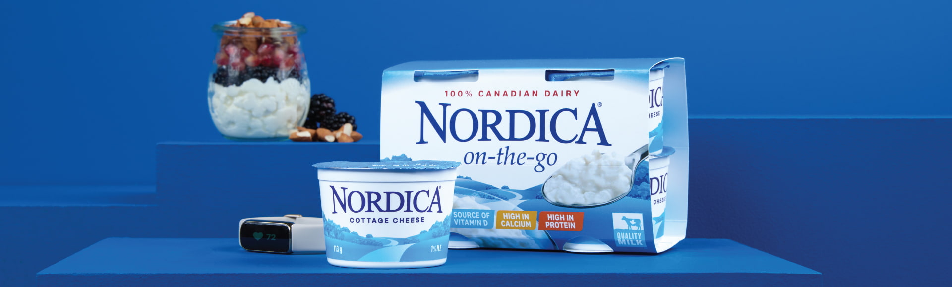 Nordica On-the-Go Plain 1% on a table with a smart watch and a parfait in the light blue background.