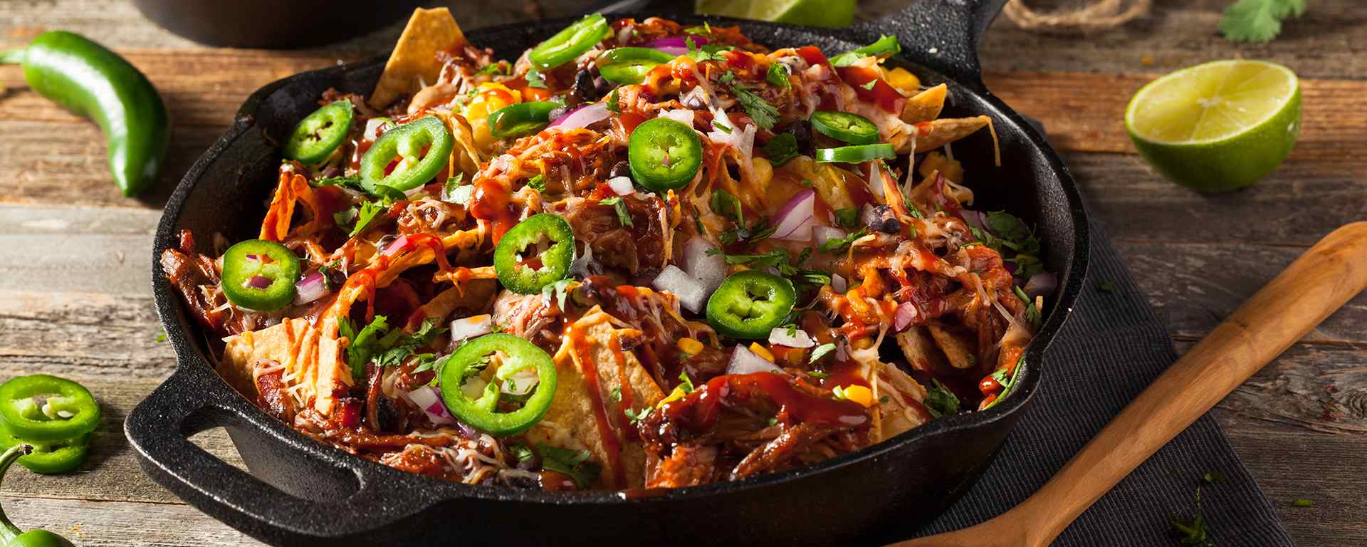 Photo of - Pulled pork nachos topped with pico di gallo and con queso drizzle